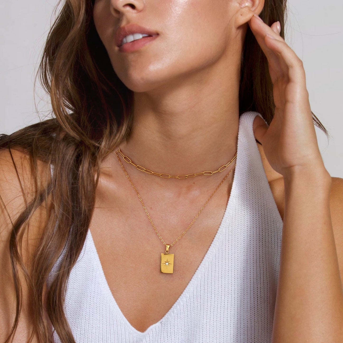 Gold-tone rectangle pendant necklace set with white stones, featuring two-layer stainless steel chains for women. 1