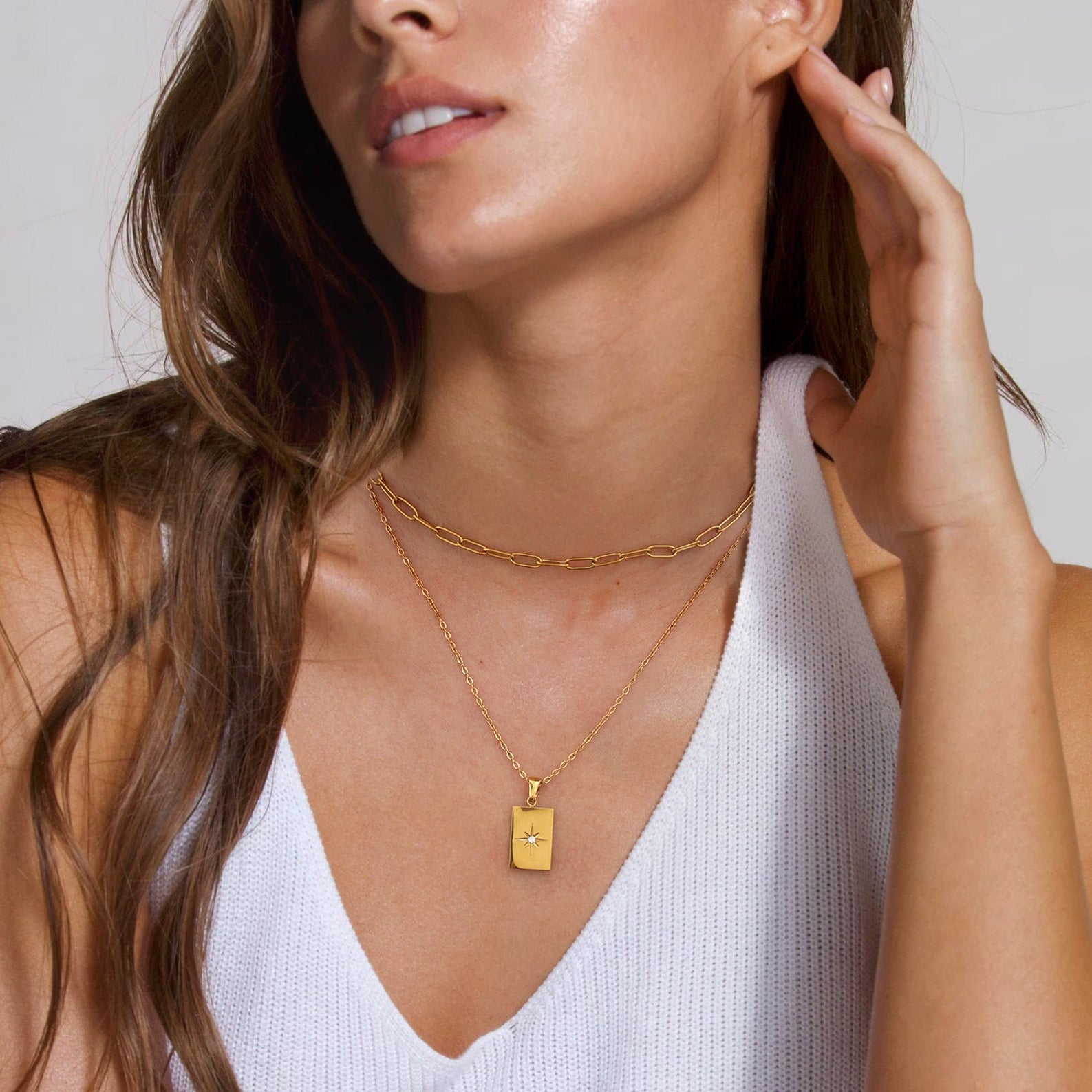 Gold-tone rectangle pendant necklace set with white stones, featuring two-layer stainless steel chains for women. 1